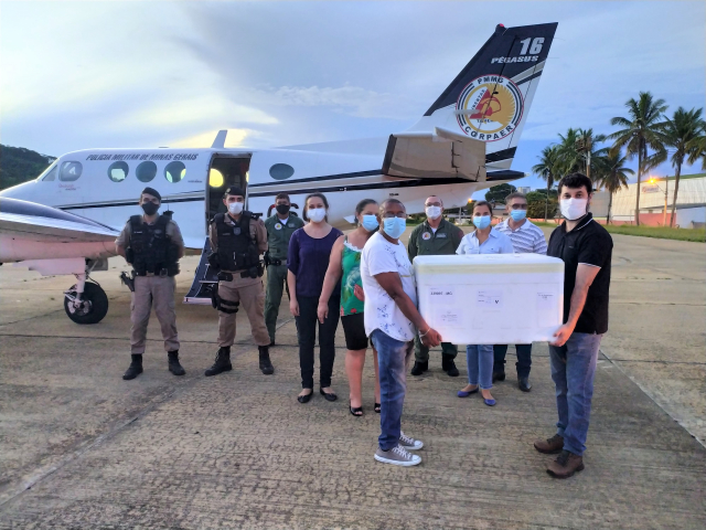 Equipe da Epidemiologia da URS Ubá recepcionando remessa de vacinas entregue no aeroporto de Ubá pelo avião da PMMG, em fevereiro