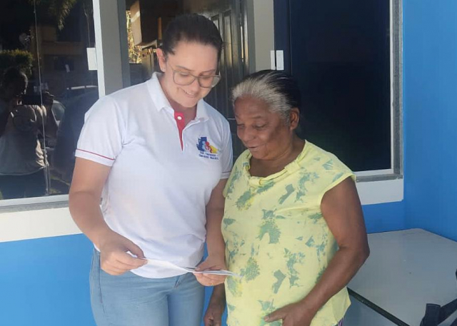 Jamile Pedrosa Moura Riguetti, enfermeira, orientando quanto a atualização da caderneta de vacinação de dona Luiza Graciano da Silva - Foto: Eneida Firmes